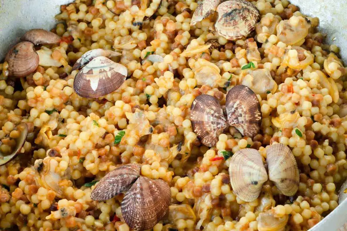 Un saporito piatto di fregola sarda con vongole e cozze, un classico della cucina sarda.