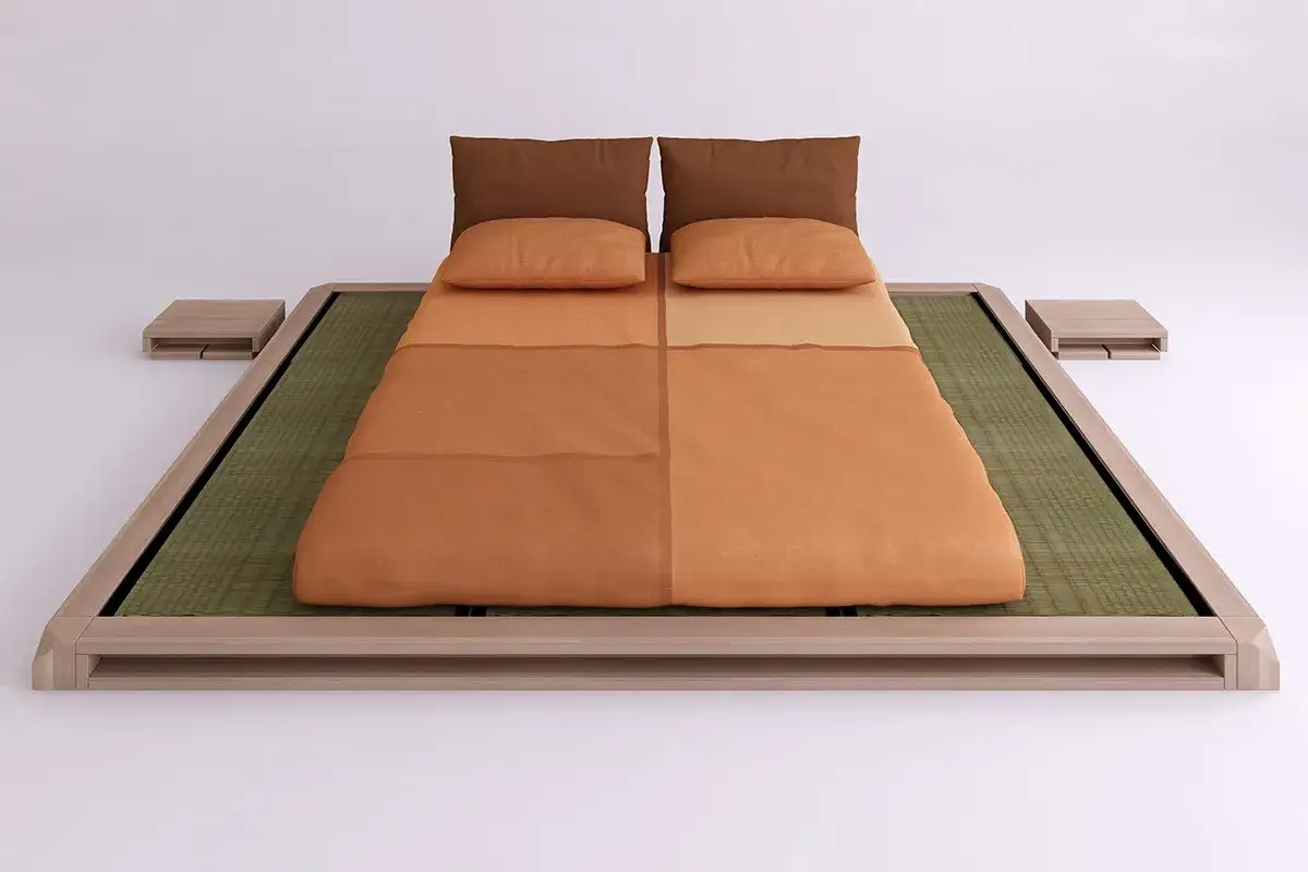 Niedriges Bett mit Tatami-Matten und einer orangefarbenen Decke, die die Matratze eines japanischen Bettes bedeckt.
