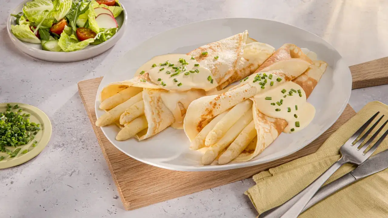 Zarte Pfannkuchen mit Spargel, übergossen mit cremiger Sauce und garniert mit Schnittlauch. Dazu ein frischer Salat.