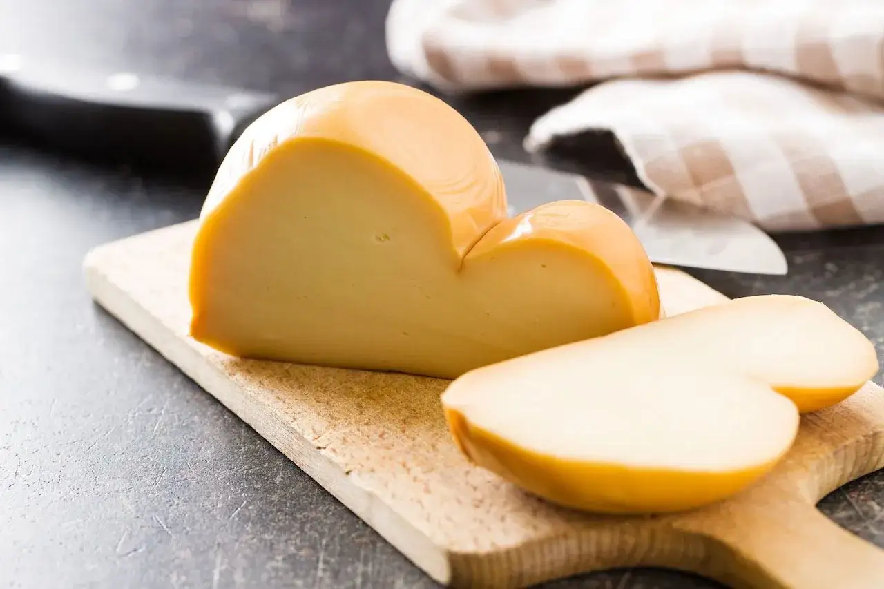 Una provola affumicata tagliata su un tagliere. Ricorda che la provola contiene lattosio, quindi fai attenzione se sei intollerante.