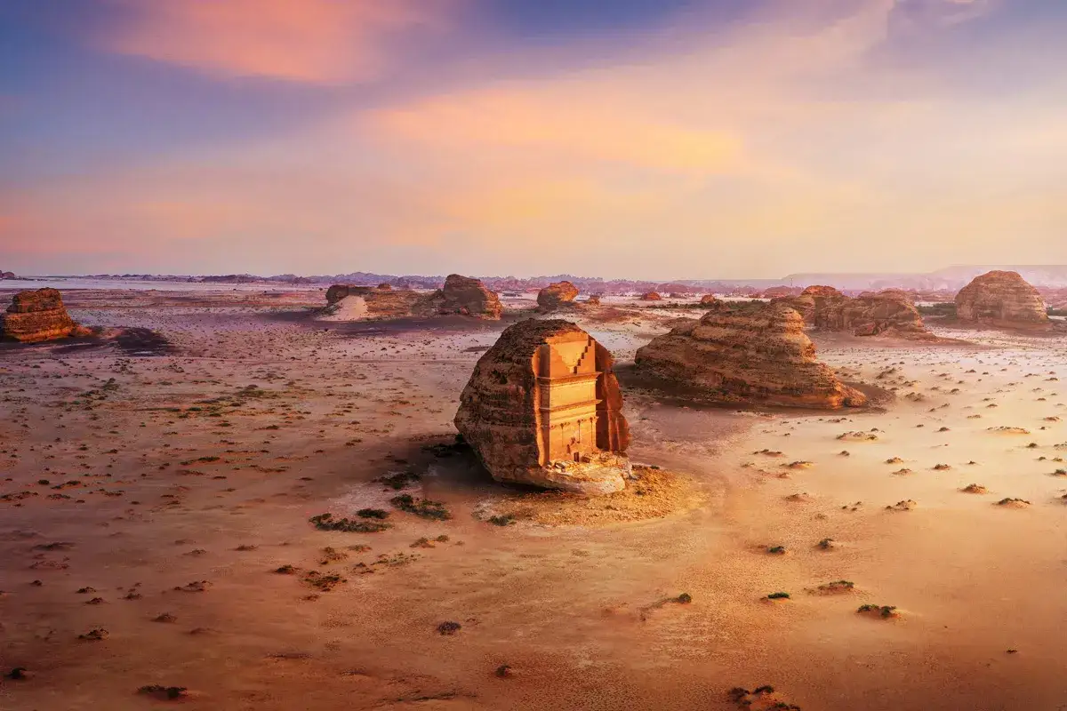 Antiche tombe nabatee scolpite nella roccia nel deserto, un luogo imperdibile da vedere in Arabia Saudita al tramonto.