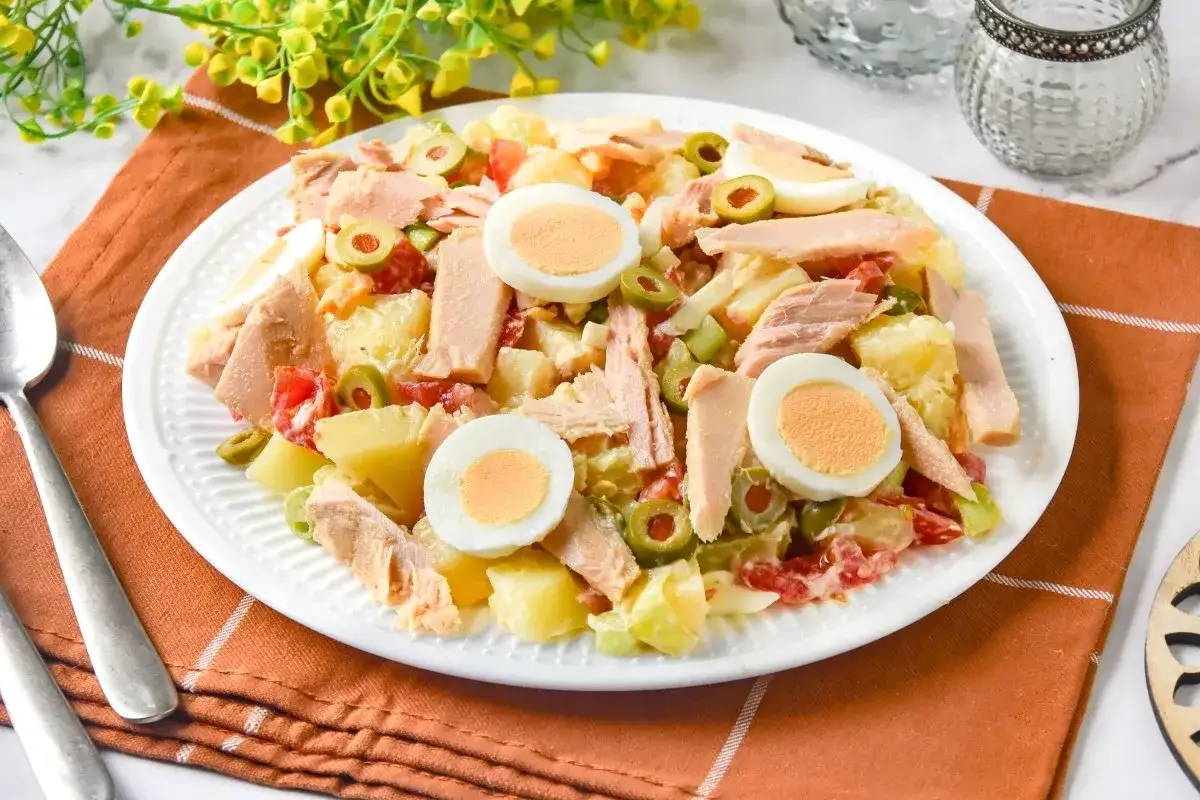 Deliciosa ensalada de patata con atún, huevo duro, aceitunas y tomate. Un plato fresco y completo.