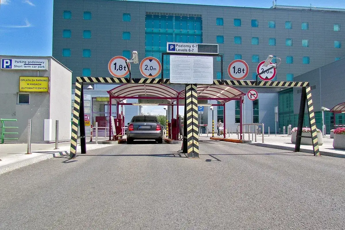 Wjazd na parking lotniska Chopina. Znak informuje o opłatach w kasach automatycznych. Sprawdź, ile kosztuje parking na lotnisku Chopina.