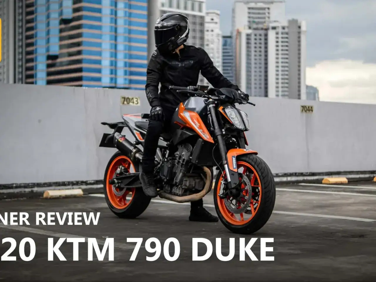Motocyklista na pomarańczowym KTM 790 Duke, gotowy do jazdy po mieście.