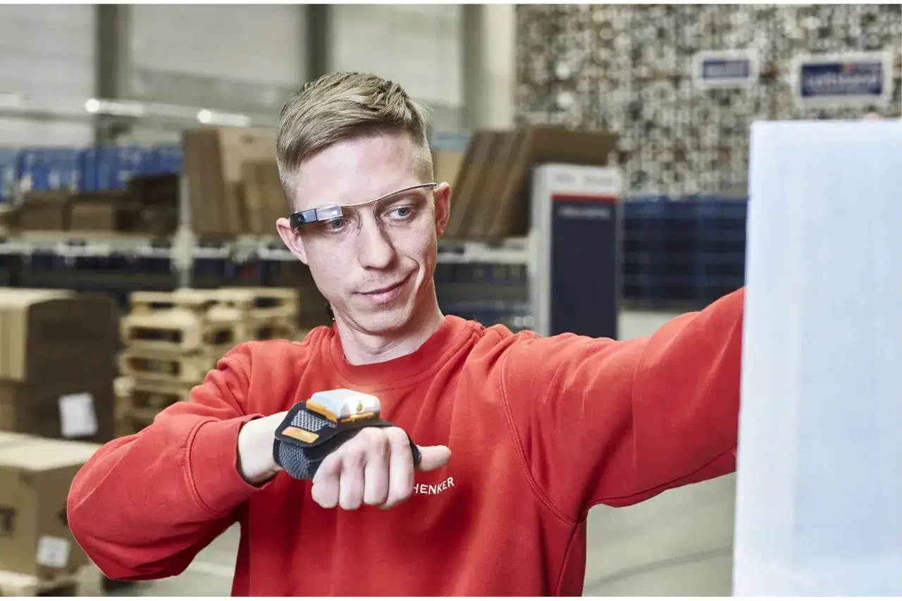 Mitarbeiter nutzt Smart Glasses und Handschuh-Scanner für Pick-by-Vision im Lager.