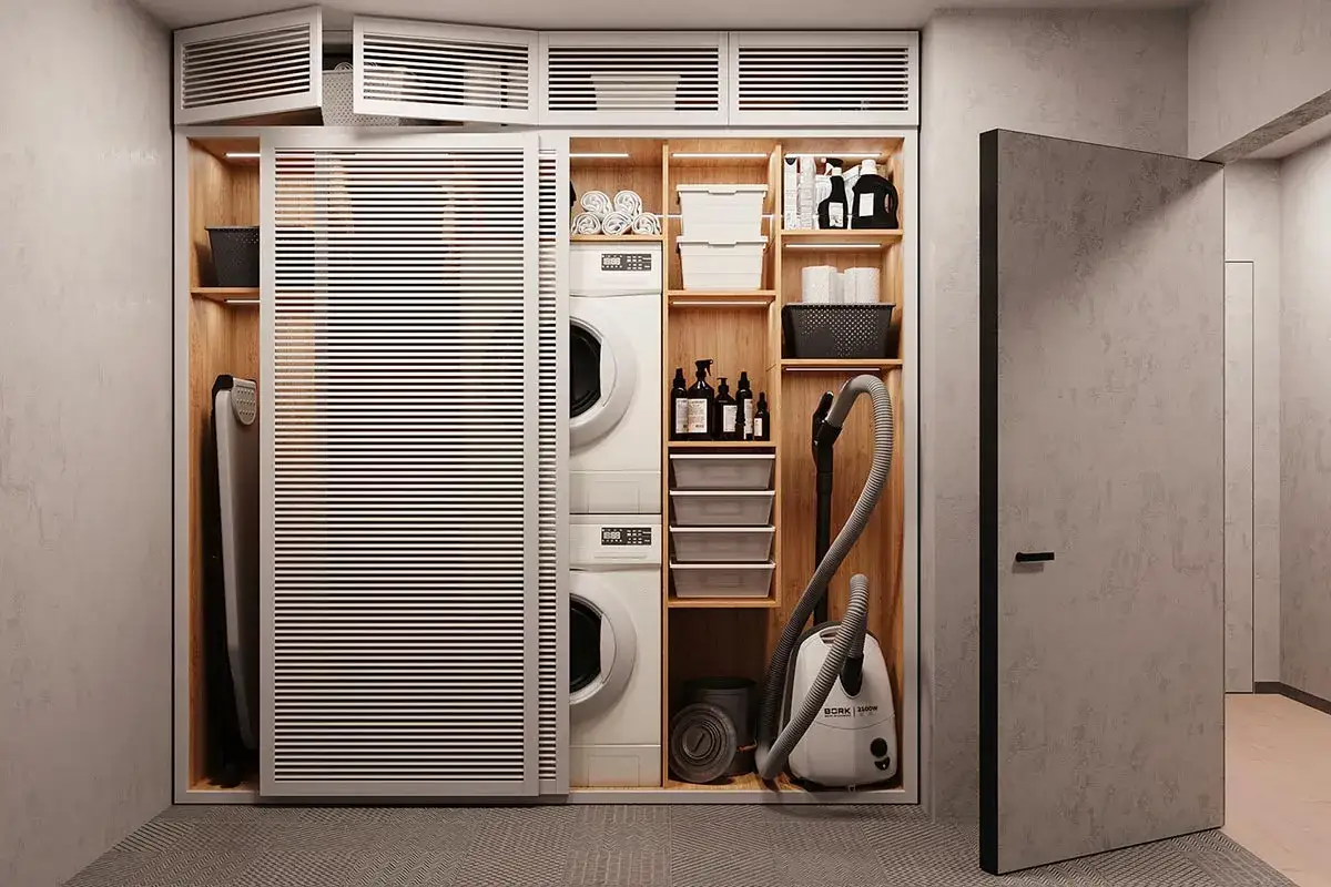 Aménagement buanderie fonctionnel avec lave-linge, sèche-linge, aspirateur, fer à repasser et rangements optimisés.