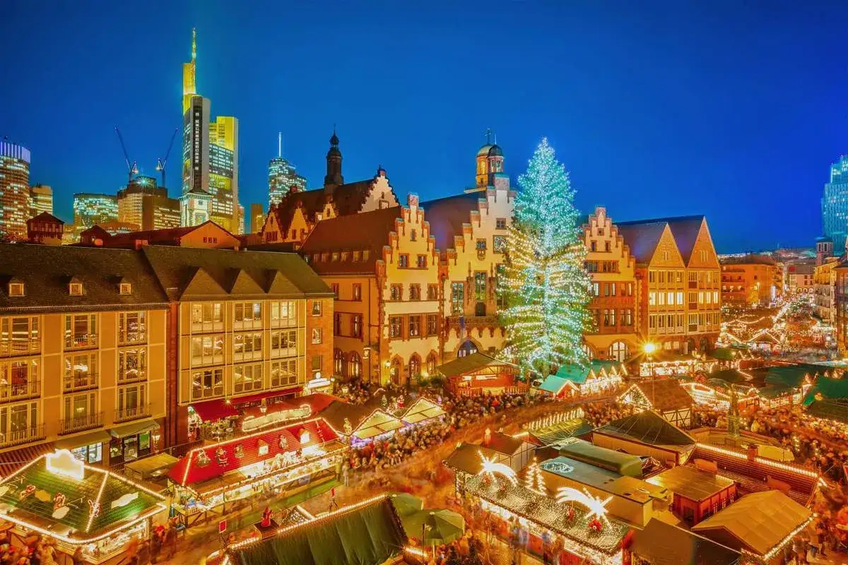 Mercados de Navidad en Alemania, con un &aacute;rbol gigante iluminado y puestos festivos bajo un cielo nocturno.