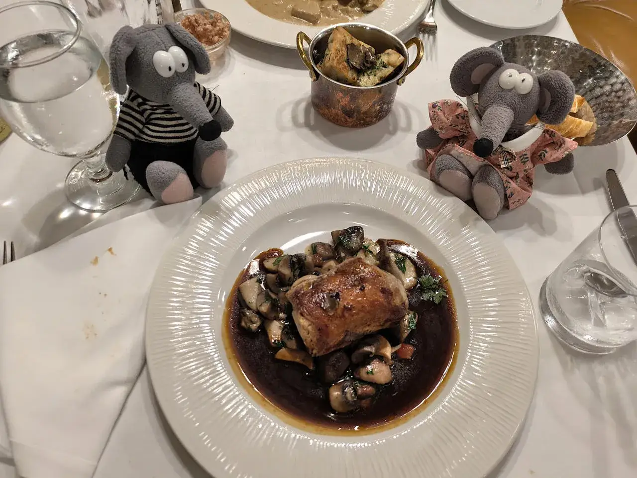Deux peluches souris dégustent un plat de viande et champignons dans un restaurant prague pas cher.