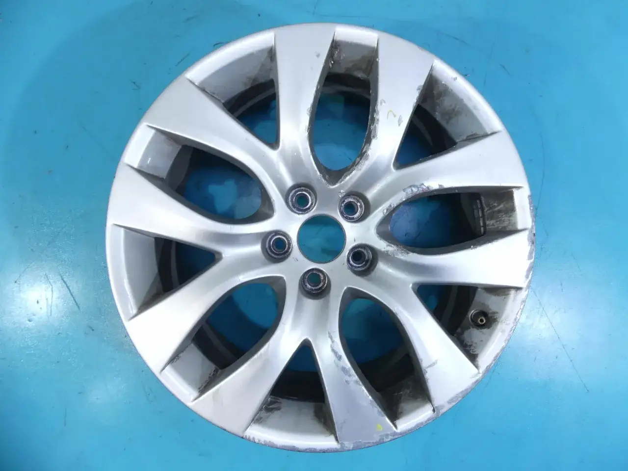 Srebrna felga aluminiowa do Citroen C5, widoczny rozstaw śrub. Felga nosi ślady użytkowania.