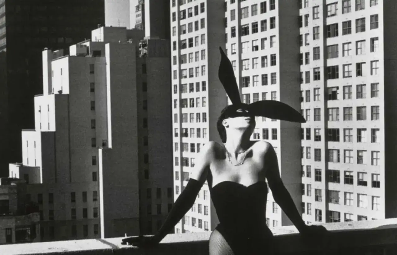 Iconica modella con orecchie da coniglio e corsetto, in un audace scatto di Helmut Newton.
