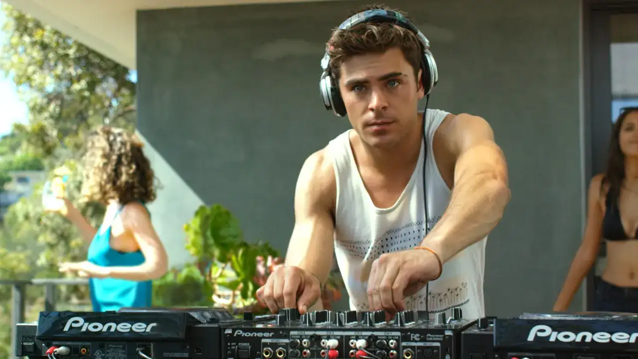 Zac Efron, nel cast di We Are Your Friends, mixa musica con cuffie e mixer.