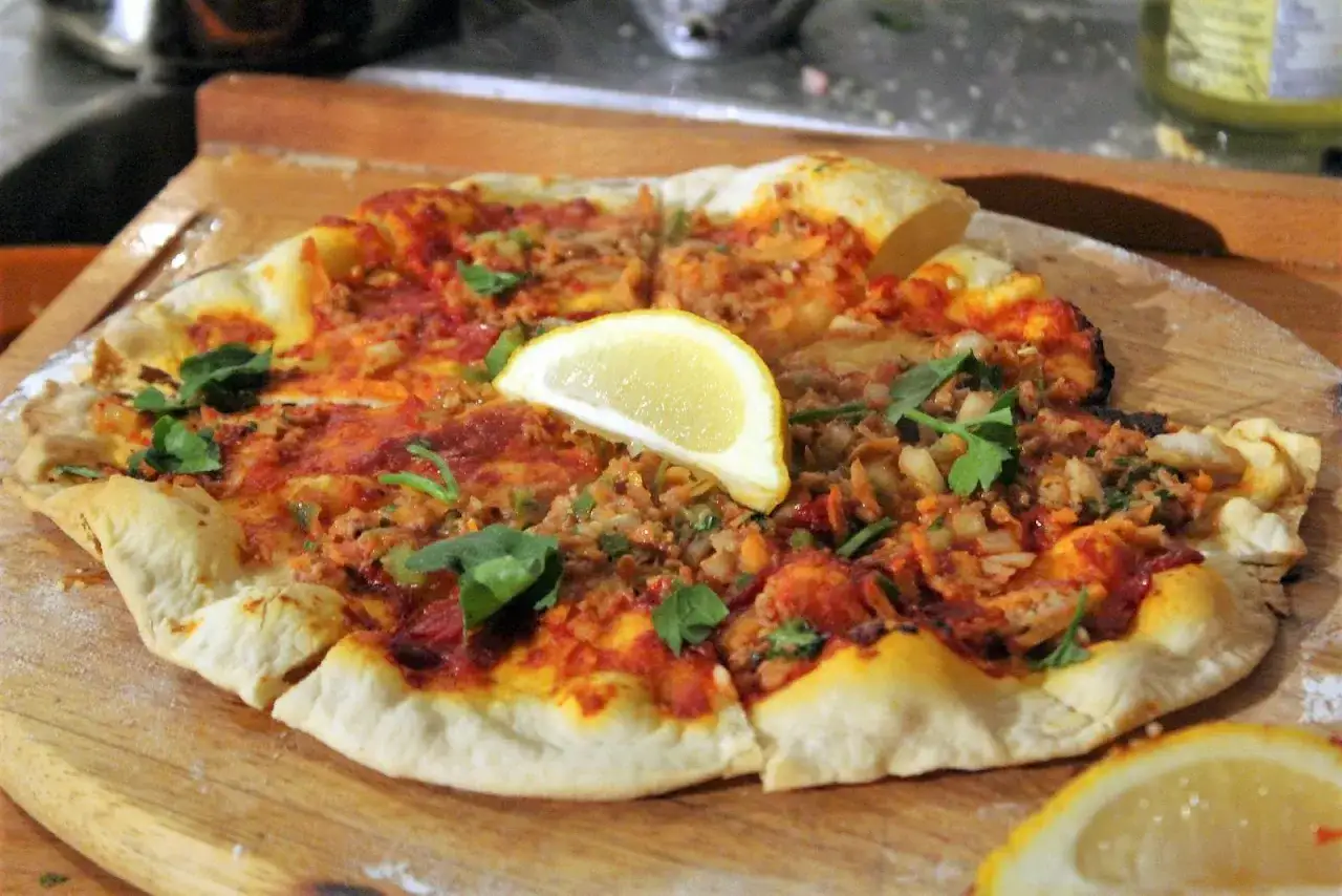 Lahmacun rezept original: Fladenbrot mit Hackfleisch, Tomaten und Kr&auml;utern, garniert mit Zitronenspalten.