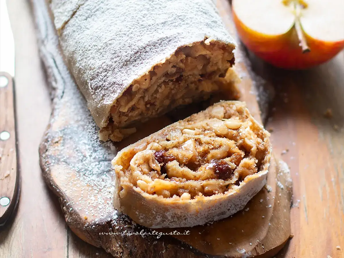 Un delizioso strudel di mele, cosparso di zucchero a velo, pronto per essere gustato.