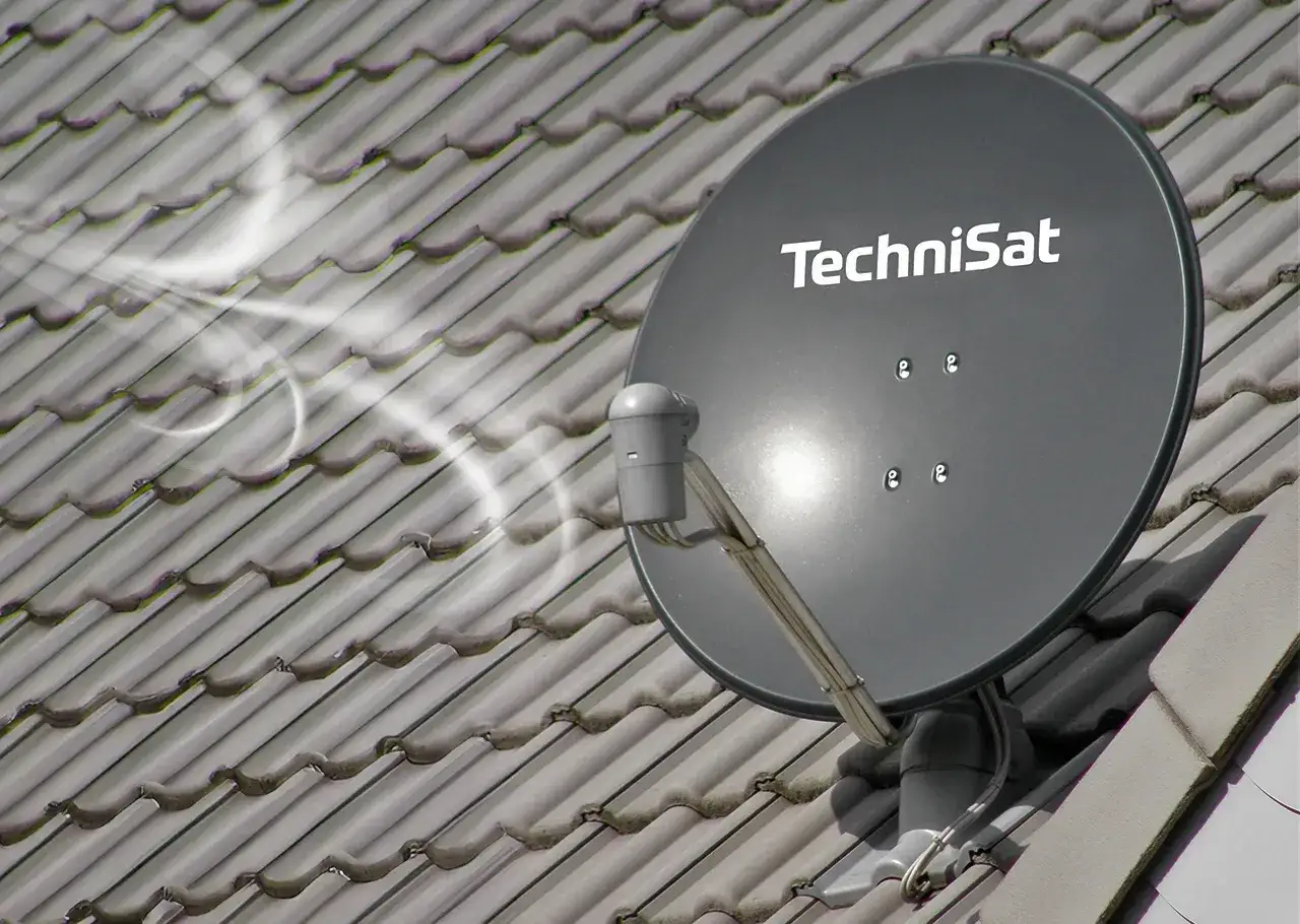 Szara antena satelitarna TechniSat na dachu. Wymiana anteny dachowej poprawiła odbiór sygnału.