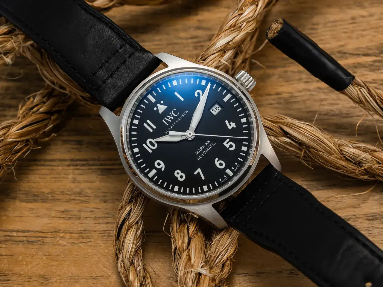 Reloj IWC Schaffhausen Mark XX Automatic con correa de cuero negro, sobre cuerdas y madera. Un clásico reloj zeno watch basel.