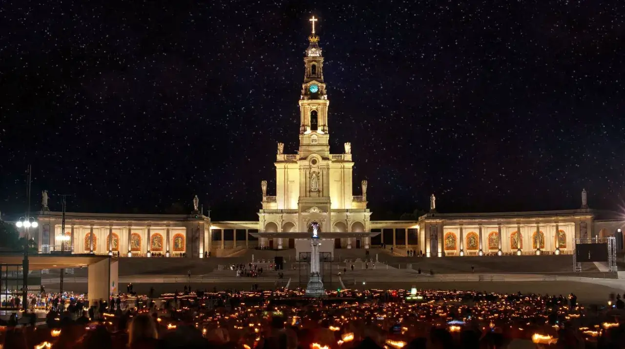 Nachtprozession mit Kerzen vor der Basilika von **heilige Fatima** unter sternklarem Himmel.