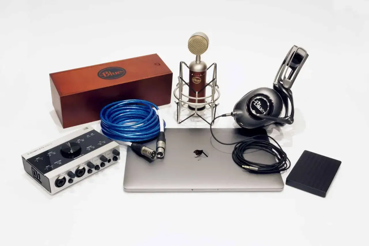 Profesjonalny zestaw do tworzenia muzyki na telefonie: mikrofon, słuchawki, interfejs audio, laptop i kable.