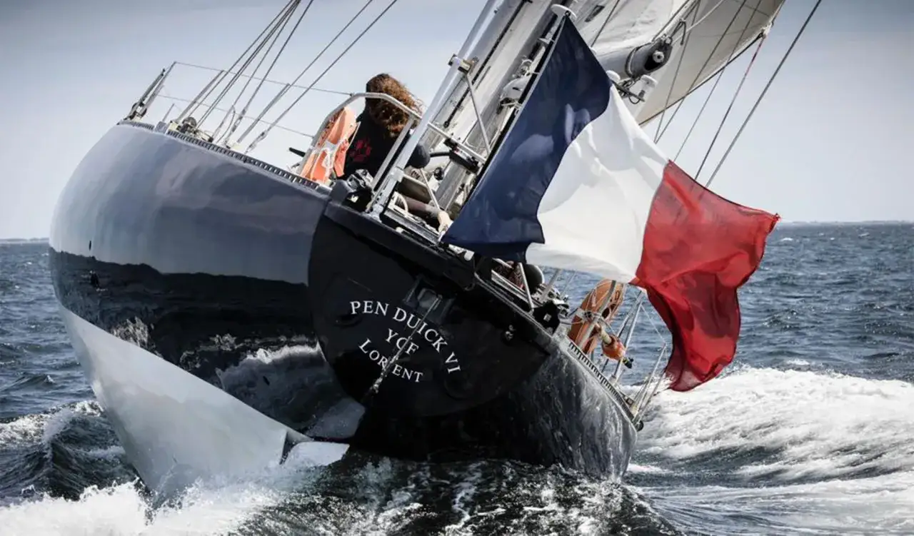 Le Pen Duick VI, naviguant fièrement sous pavillon français, avec Marie Tabarly à son bord, fend les vagues.