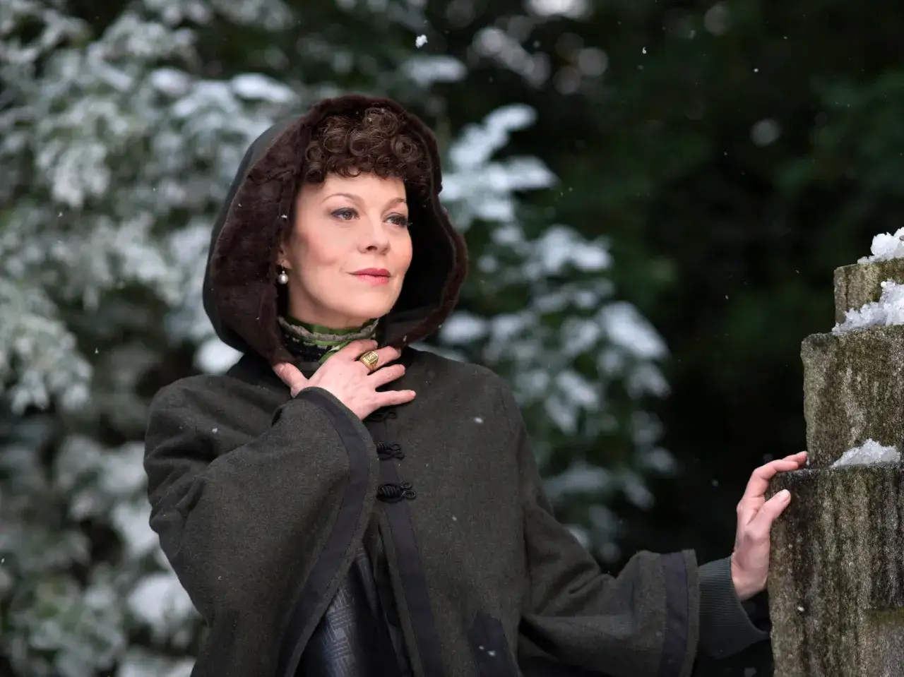 Helen McCrory w zimowej scenerii, w płaszczu z kapturem. Aktorka znana z wielu filmów, seriali i programów.