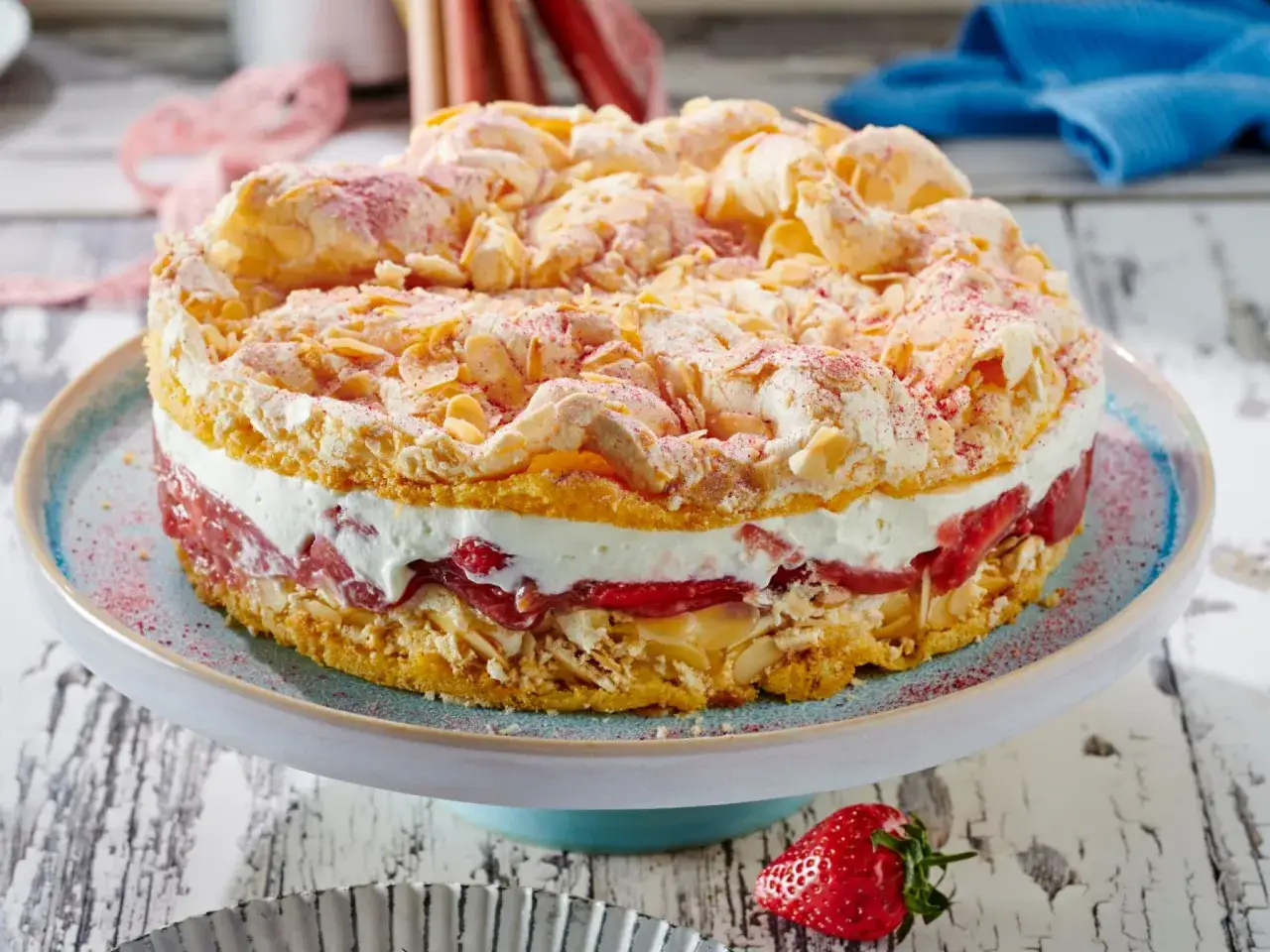 Saftige Rhabarbertorte mit Baiserhaube, Mandelsplittern und Erdbeeren. Ein köstliches Rhabarbertorte Rezept für den Sommer.