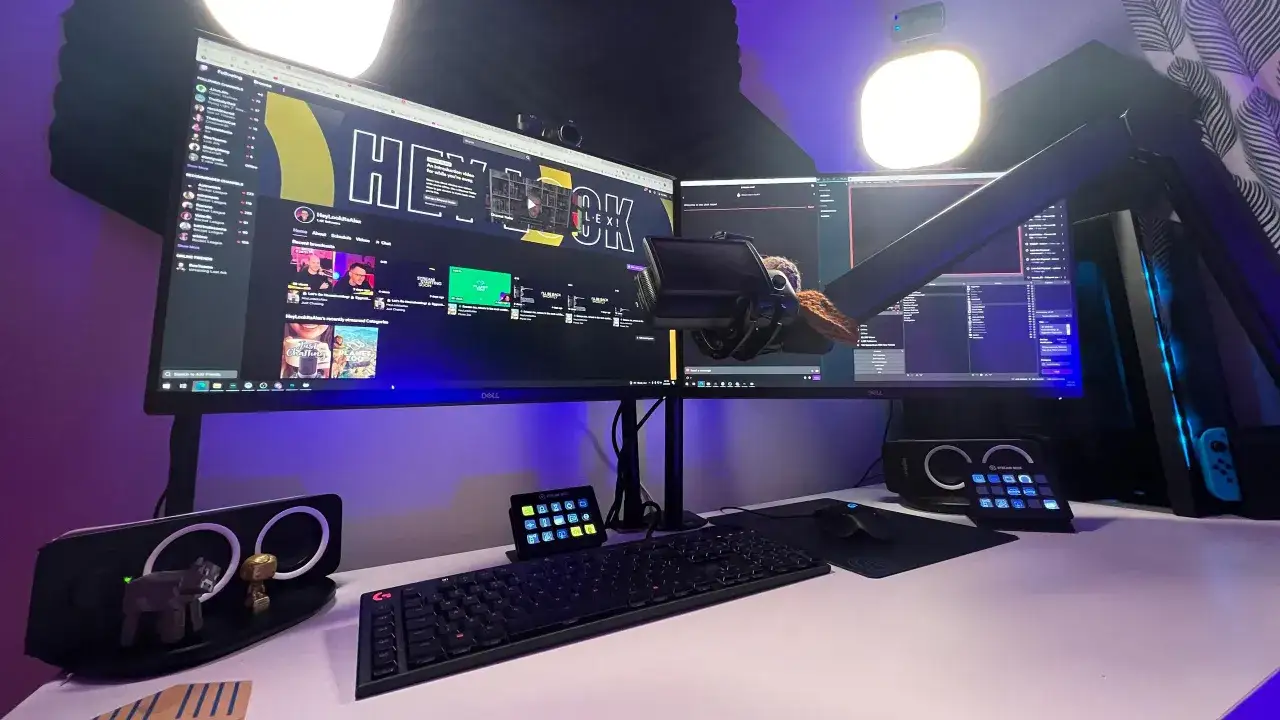 Stanowisko gamingowe z dwoma monitorami, klawiaturą i myszką. Na ekranie widać platformę streamingową, idealną, by zarabiać na grach.