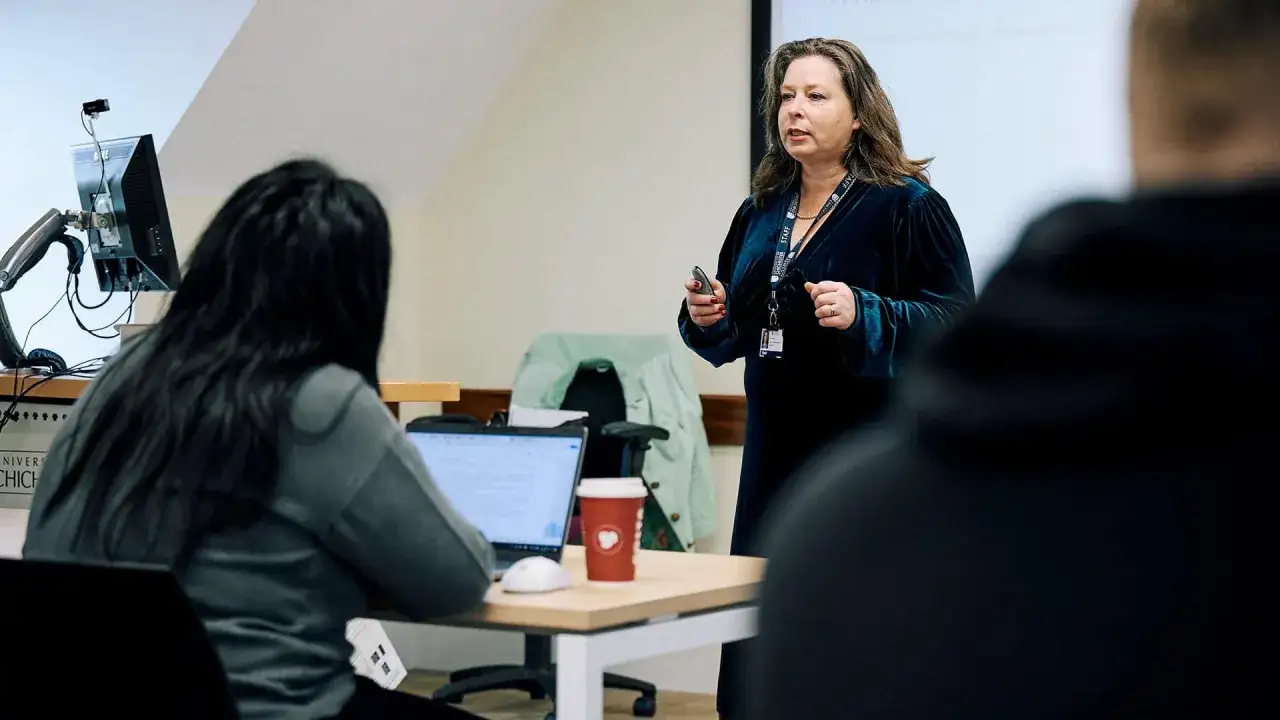 A woman presents on MBA organizational leadership to students in a classroom.