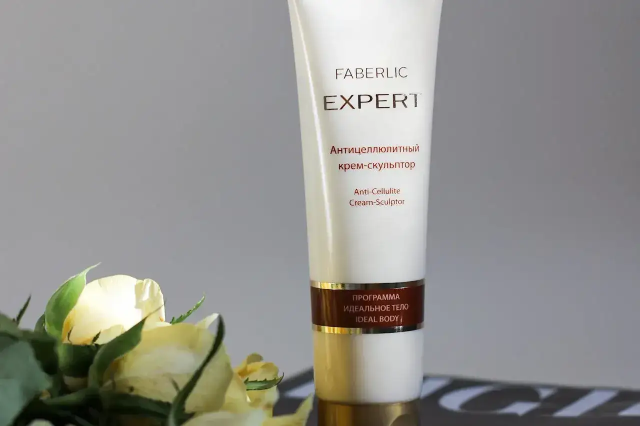 Krem Faberlic Expert Anti-Cellulite Cream-Sculptor, najlepszy krem na cellulit, obok delikatnych żółtych róż.