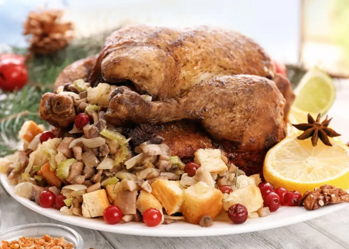 Un delicioso pavo relleno al horno, adornado con arándanos, limón y especias, listo para celebrar.