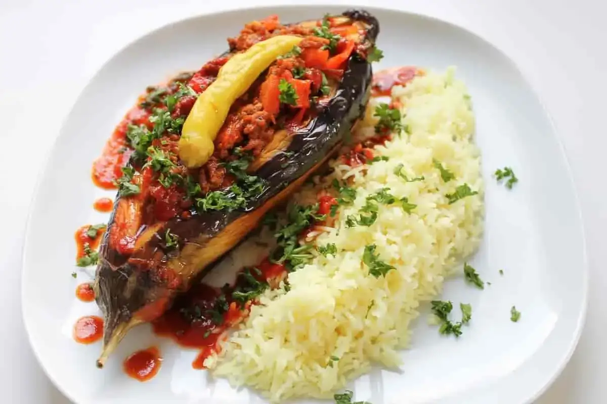 En halv aubergine fylld med k&ouml;ttf&auml;rs och gr&ouml;nsaker, serverad med ris och en gul chili. En l&auml;cker imam bayildi.