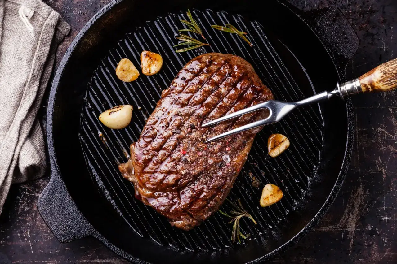Una succulenta bistecca di manzo, tra i migliori tipi di bistecche di manzo, cotta in padella con aglio e rosmarino.