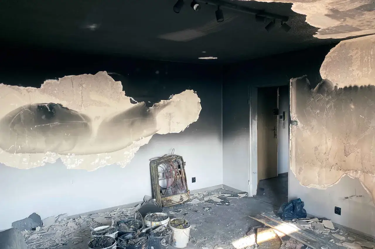 Spalone wnętrze, okopcone ściany i sufit. Na podłodze gruz, wiadra z odpadami i zniszczony grzejnik. Zastanawiasz się, czym zmyć okopcone ściany po pożarze?