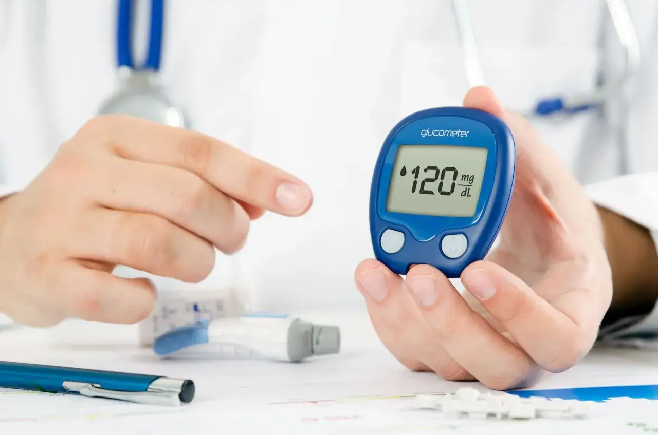 Lekarz pokazuje glukometr z wynikiem 120 mg/dL, sugerując potrzebę monitorowania w kontekście cukrzycy typu 3.
