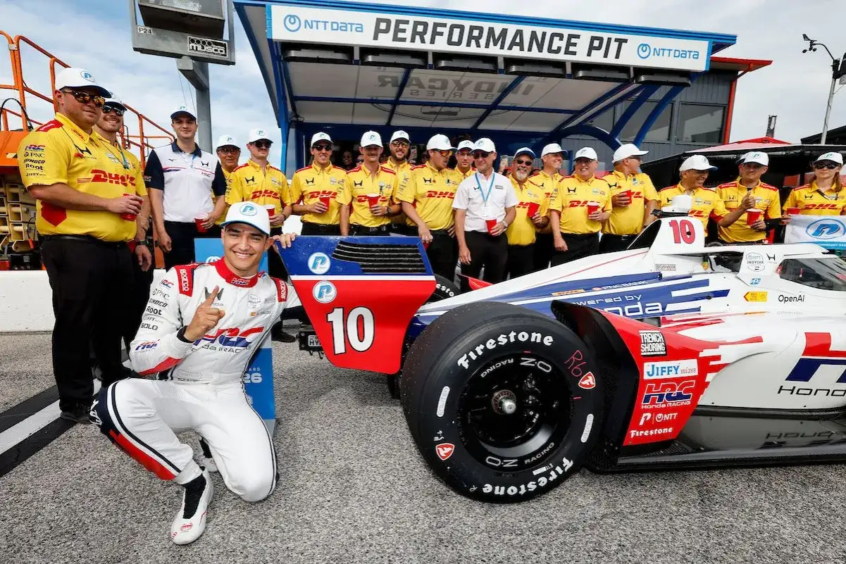 Alex Palou, piloto de IndyCar, posa con su equipo y el coche n&uacute;mero 10.