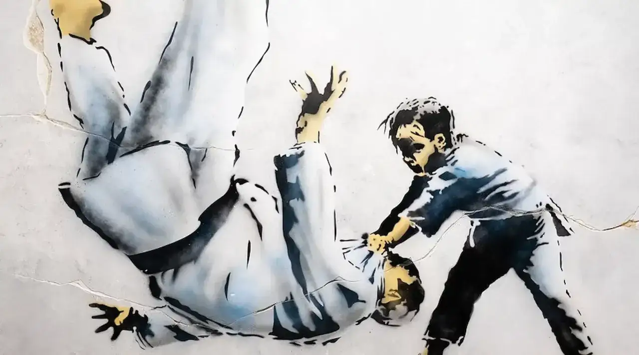 Banksy in Lissabon: Ein Kind wirft einen Erwachsenen im Judo-Gürtel um.