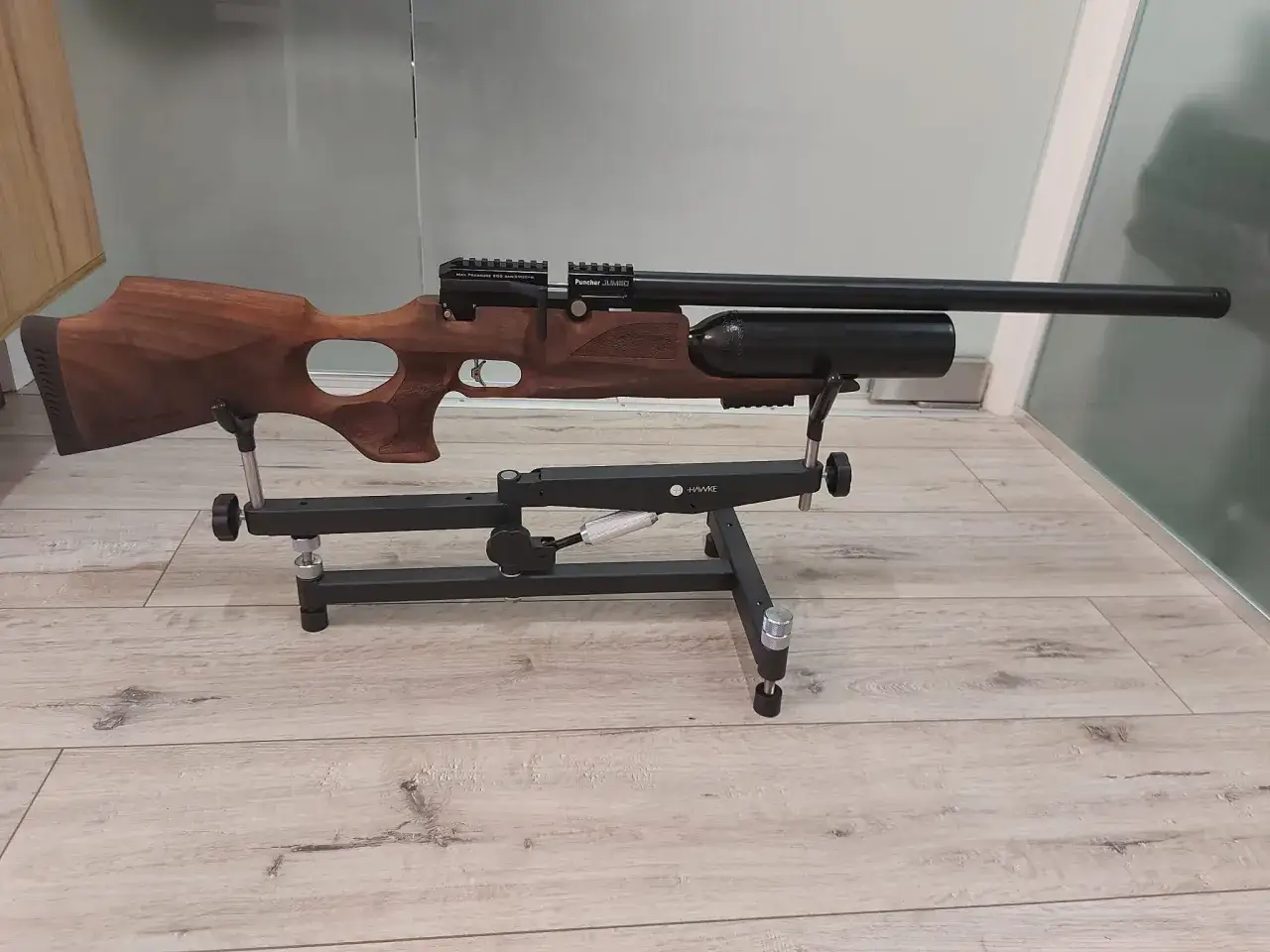Elegancki karabin pneumatyczny Kral Puncher Jumbo z drewnianą osadą, prezentowany na czarnym stojaku.