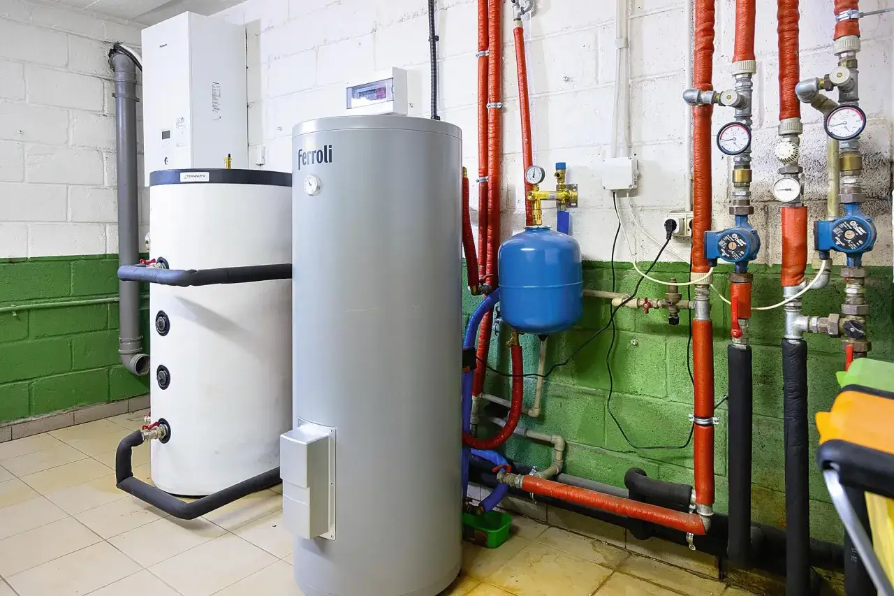 Kotłownia z dwoma bojlerami, pompami i rurami. To przykład instalacji, kt&oacute;ra może być częścią ekoprojektu, dbającego o efektywność energetyczną.