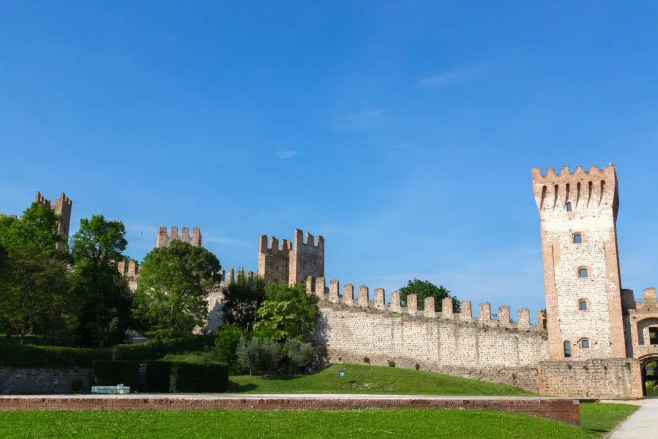 Mura medievali con torri e vegetazione lussureggiante, un luogo incantevole da scoprire: cosa vedere a Este.