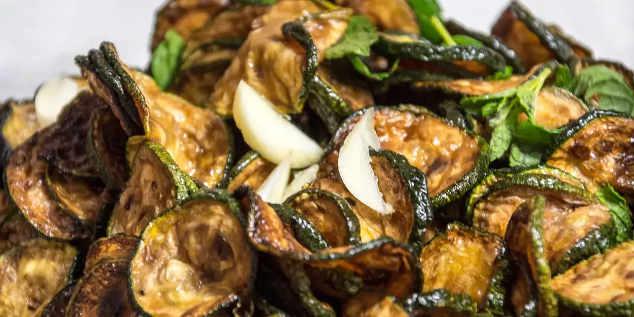 Zucchine alla scapece non fritte, dorate e saporite, con aglio e menta fresca. Un contorno leggero e gustoso.