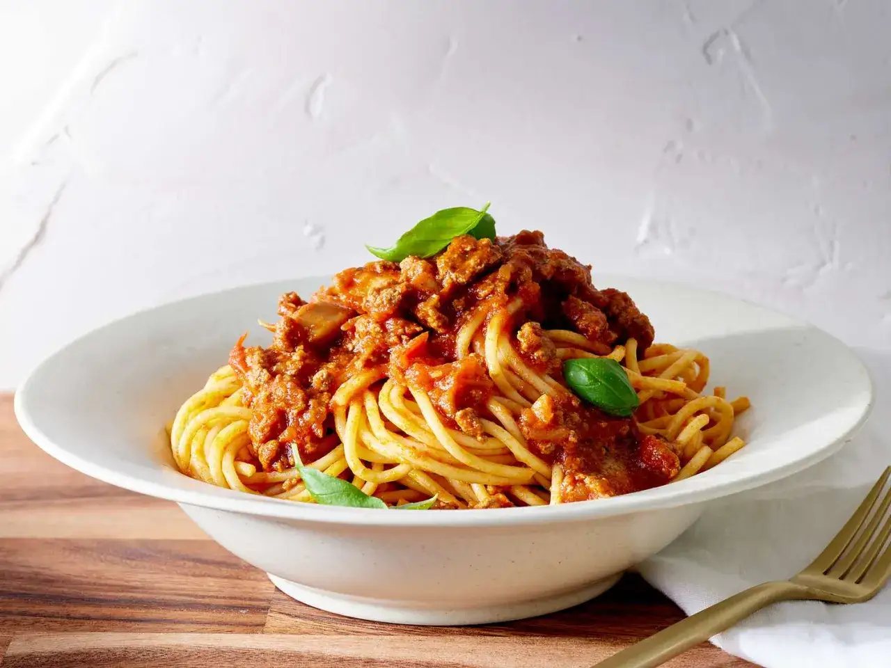 Ein Teller Spaghetti Napoli mit herzhafter Bolognese-Sauce und frischem Basilikum.