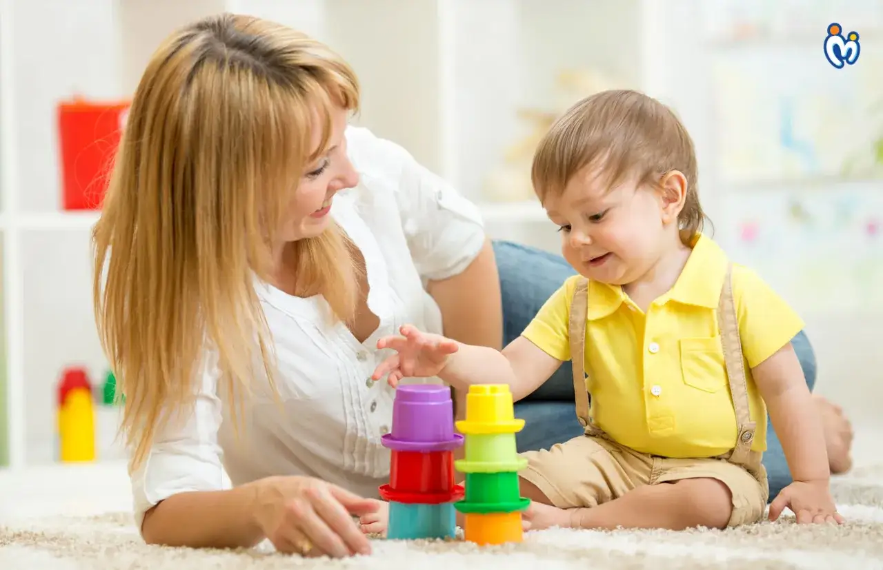 Mama i dziecko budują wieżę z kolorowych kubeczków. To wspaniały skok rozwojowy 18 miesiąc!