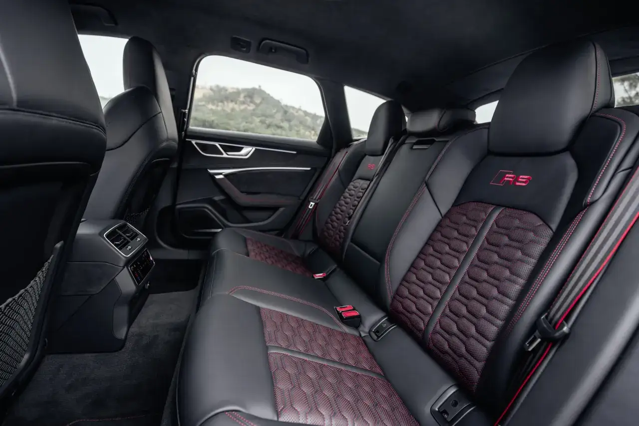 Wnętrze Audi RS6 z czarną skórzaną tapicerką i czerwonymi przeszyciami. Luksus i sportowy charakter, który wpływa na audi rs6 cena.