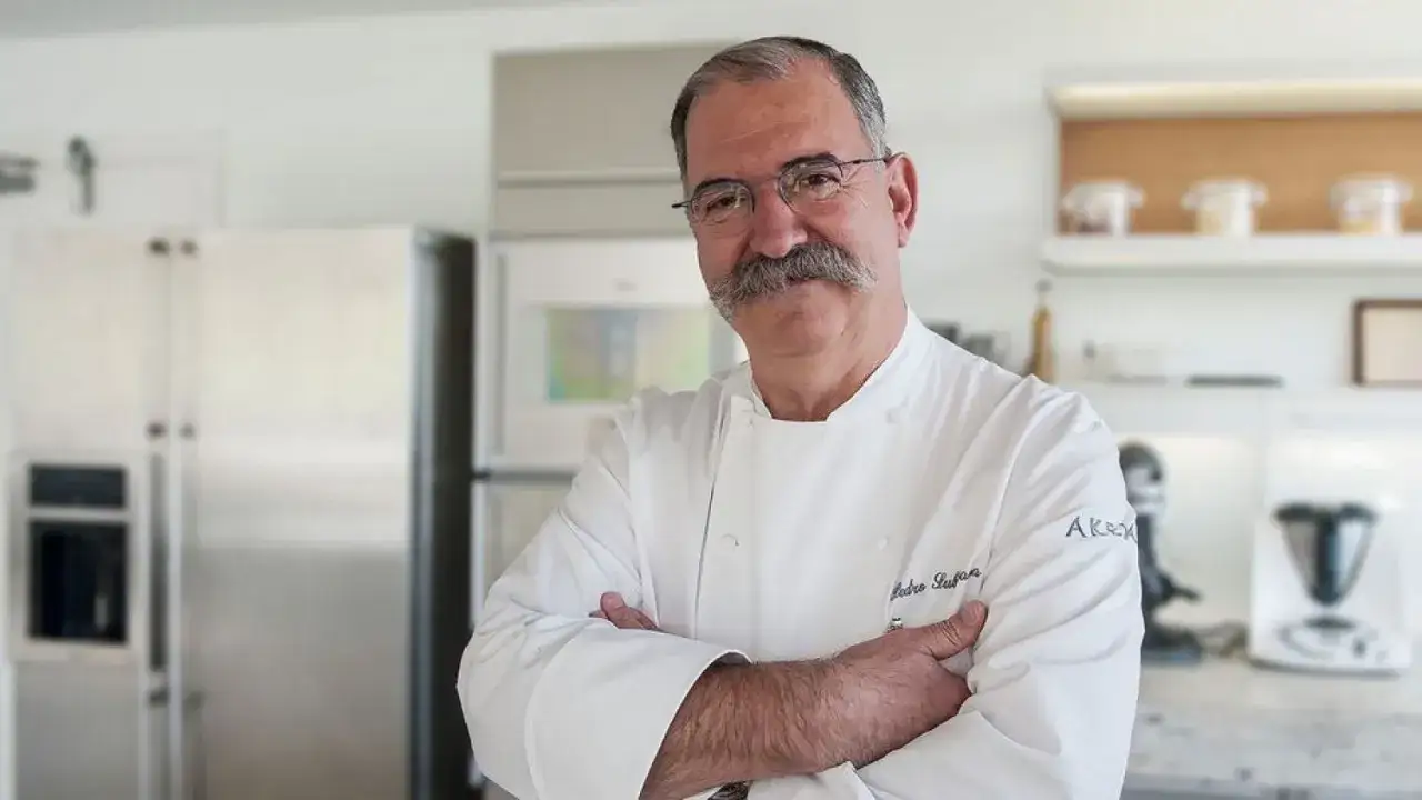 Chef español con estrella Michelin, con bigote y gafas, posa en una cocina moderna.