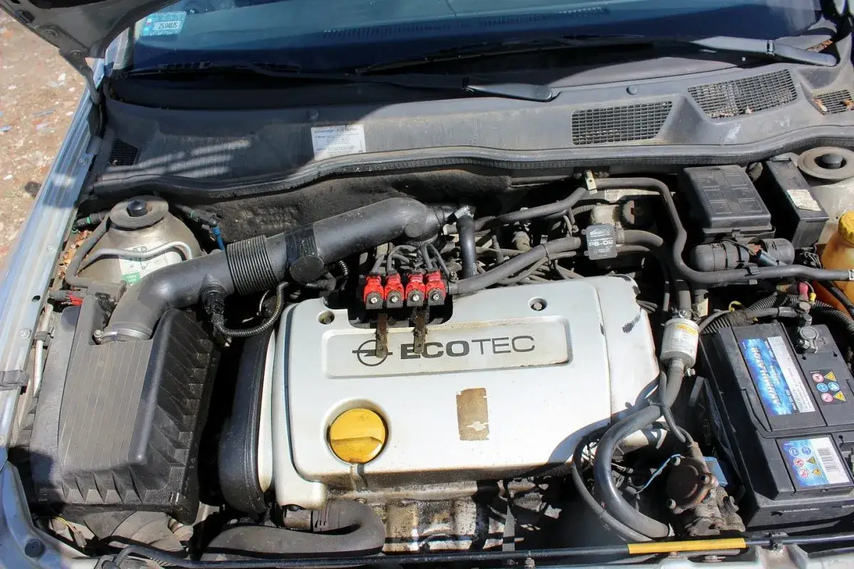 Silnik Opel Astra G 1.6 16V Ecotec z instalacją LPG. Widoczne wtryskiwacze gazowe, akumulator i elementy układu dolotowego.
