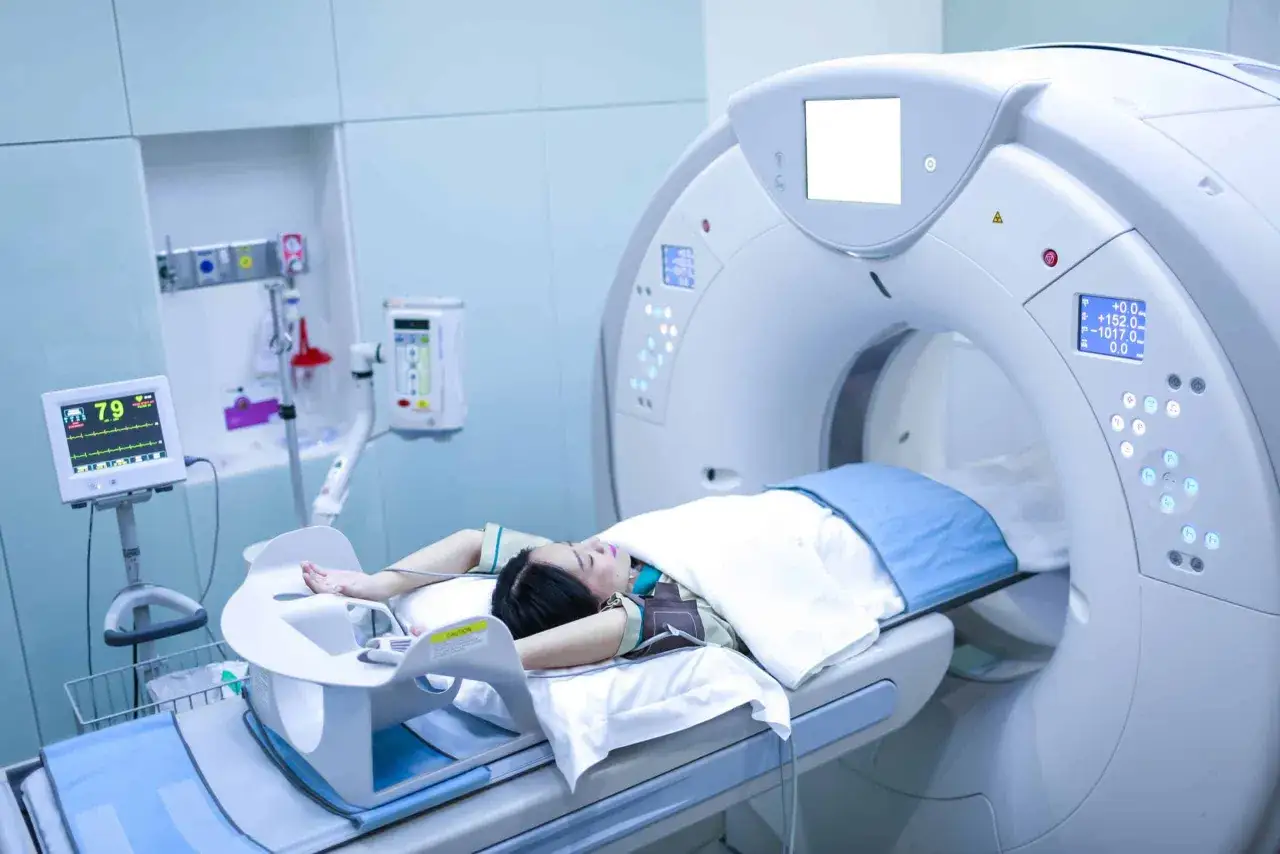 Frau liegt auf einem CT-Scanner, um einen möglichen **tumor im bauch** zu untersuchen. Überwachungssysteme zeigen Vitalwerte.