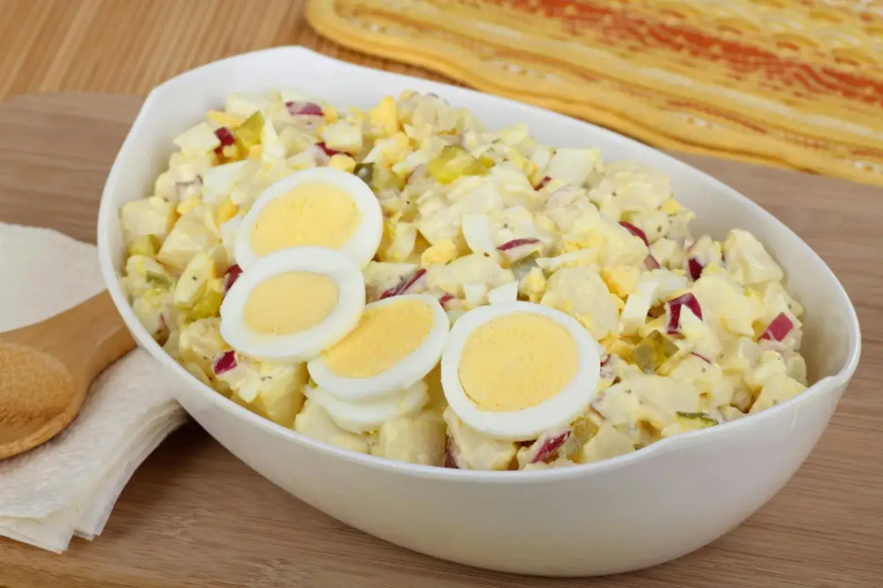 Ein großer Napf mit cremigem Kartoffelsalat, garniert mit Eierscheiben. Dieser 7 Tassen Salat ist perfekt für jede Feier.
