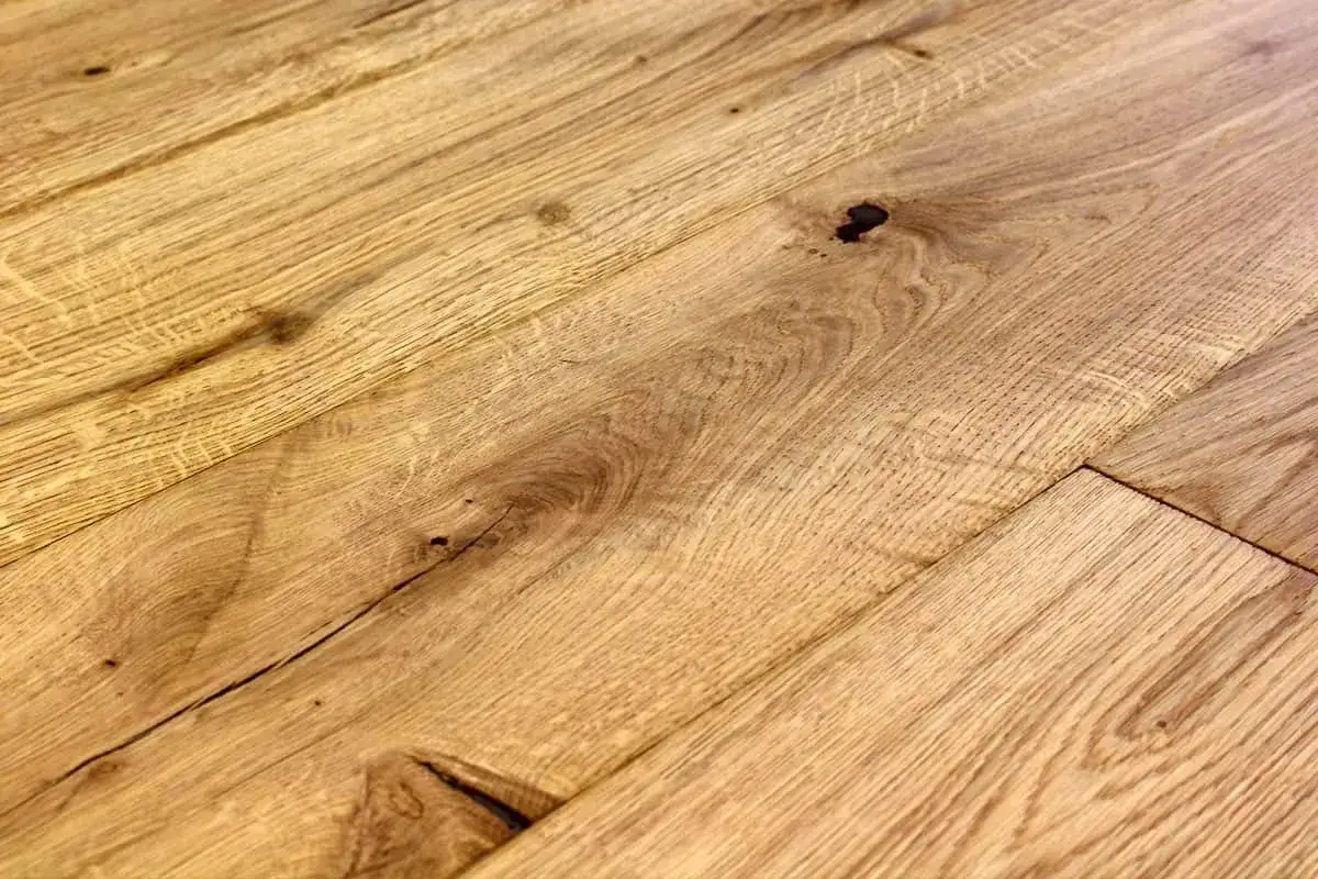 Dettaglio di assi di legno di quercia con venature marcate e nodi scuri, che evocano un effetto naturale per chi cerca come invecchiare il legno.