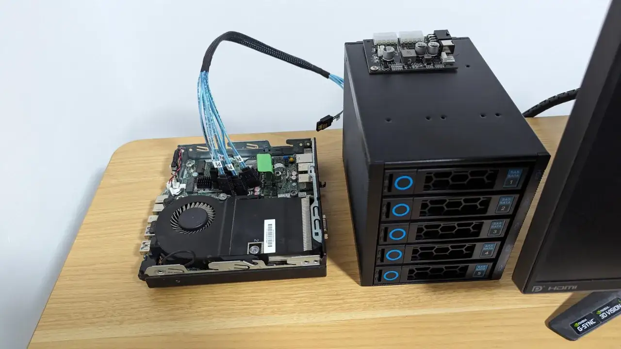 Einbau eines Homeservers: Mainboard mit L&uuml;fter und SATA-Kabeln neben einem schwarzen Geh&auml;use mit f&uuml;nf Einsch&uuml;ben f&uuml;r Festplatten.