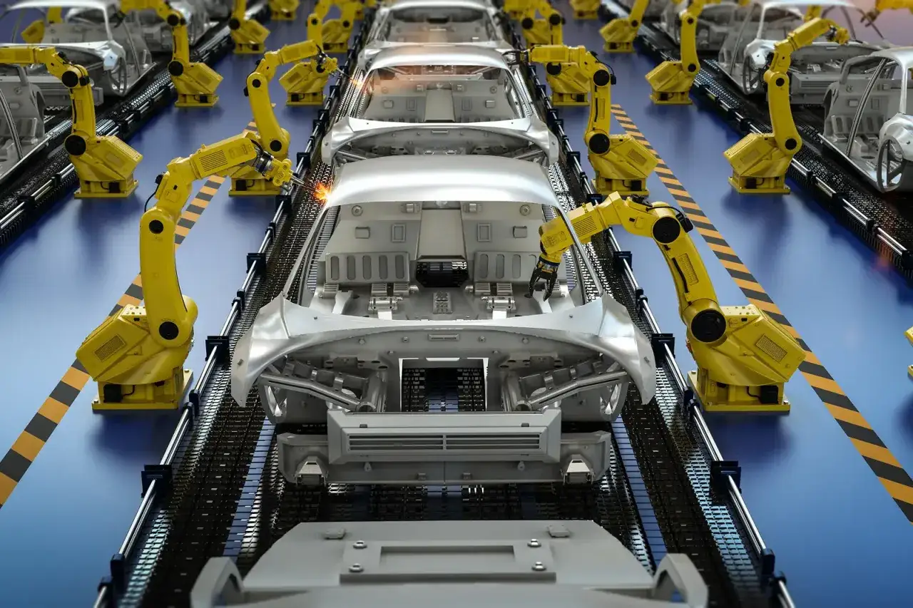 Linia produkcyjna samochodów, gdzie żółte roboty wykonują audyt IATF, spawając karoserie.