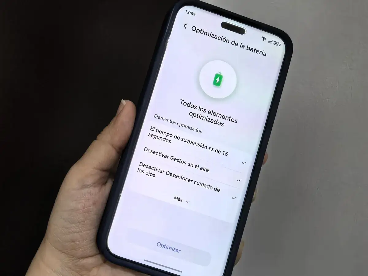 Mano sujetando un m&oacute;vil con la pantalla mostrando la optimizaci&oacute;n de la bater&iacute;a. Ideal para saber cu&aacute;ndo cargar el m&oacute;vil.