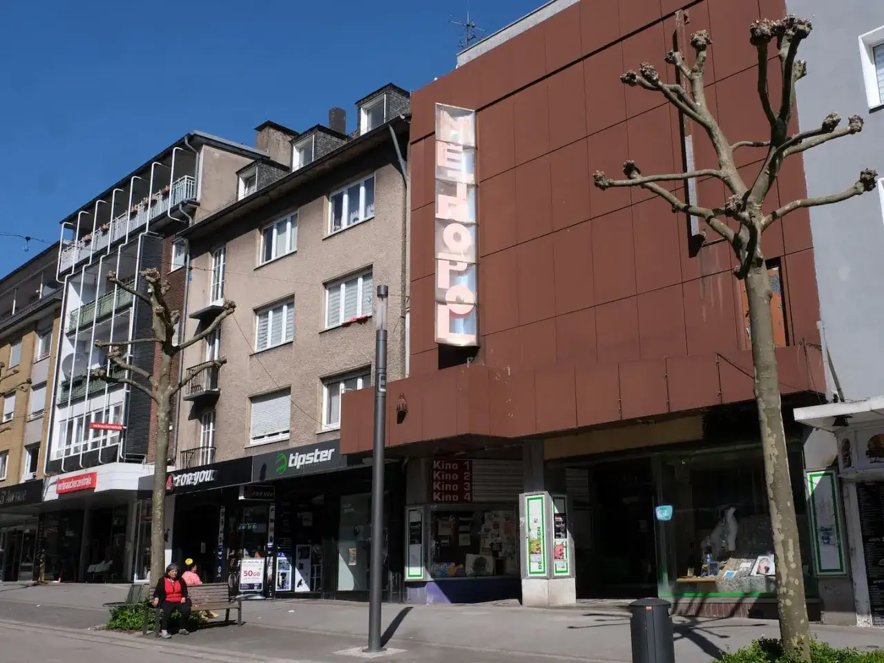 Das METROPOL Kino in Remscheid zeigt stolz seine vier Kinos&auml;le. Ein Baum steht davor.